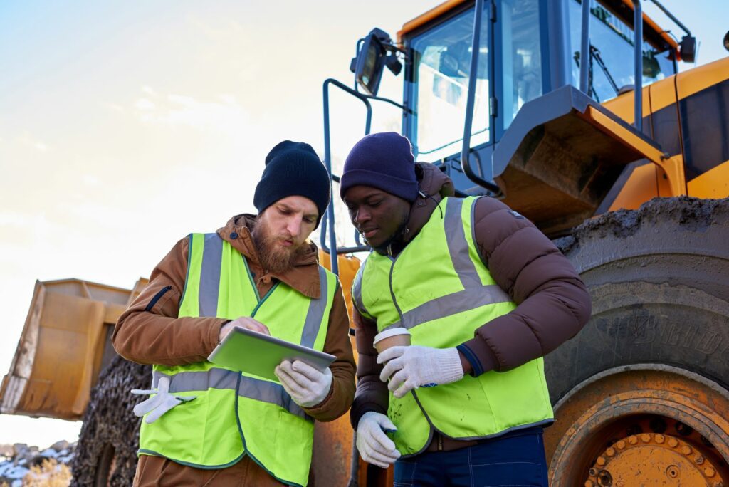 Two men looking at data in mining operation