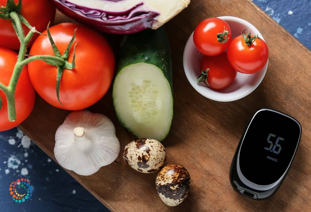 Tomatoes, garlic, and other vegetables on cutting board with glucose monitor